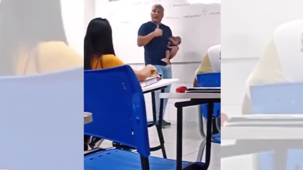 Professor com bebê de aluna no colo durante aula