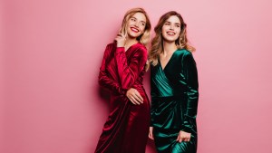 Two women posing for photo in velvet dresses