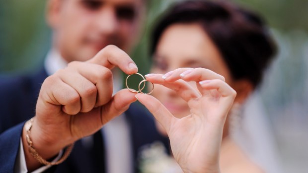 bride and groom holding hands in a ring