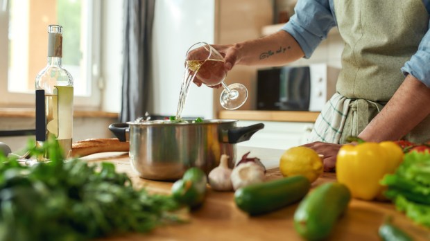 Chef pouring wine into the dish