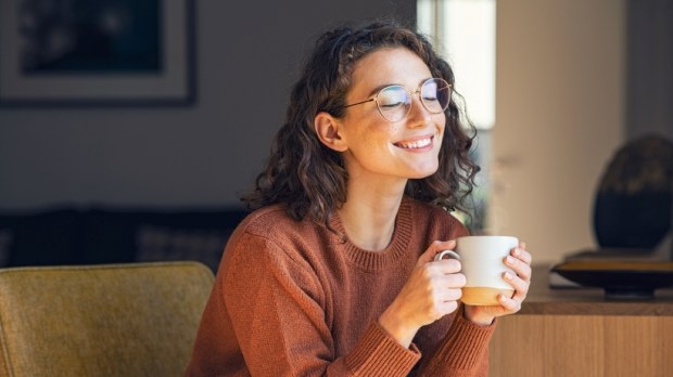 Happy young woman drinking a cup of tea