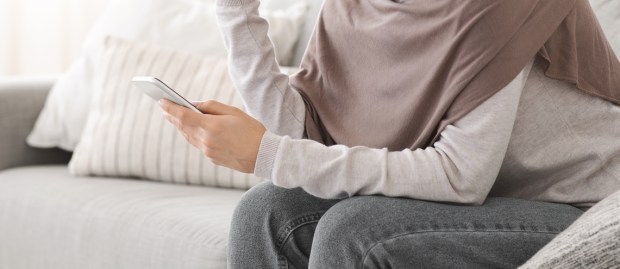 Muslim woman looking at phone