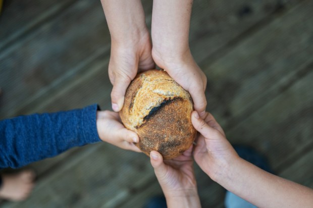 Hands-of-a-family-holding-bread-bun-shutterstock_1718885203.jpg