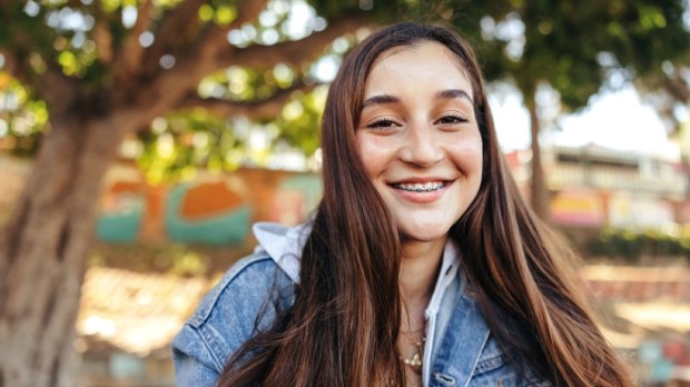 Smiling teenage girl looking at the camera outdoors