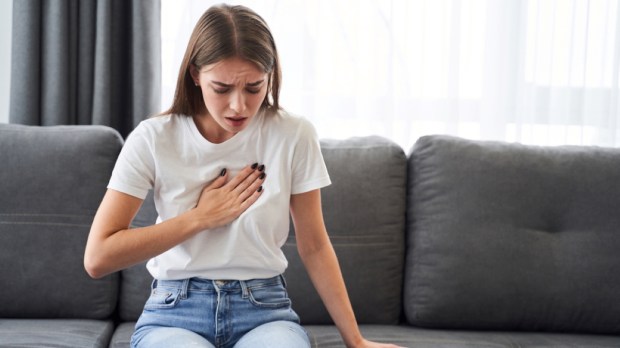 Woman sitting with strong chest pain