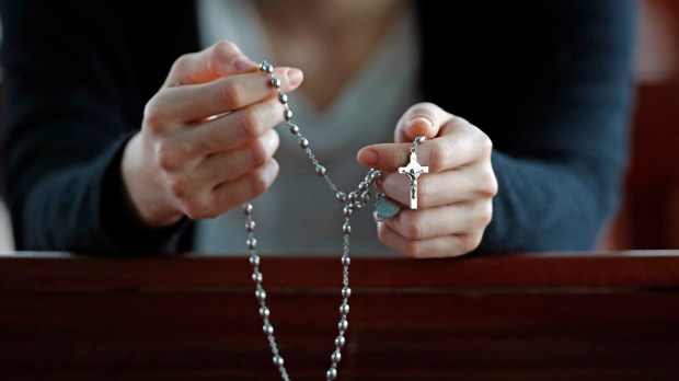 mujer rezando el rosario
