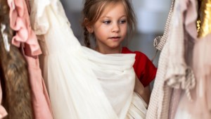 little girl choosing clothes trying on a new dress