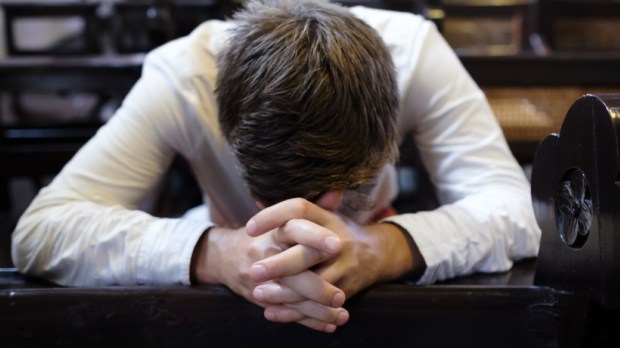 man praying in church