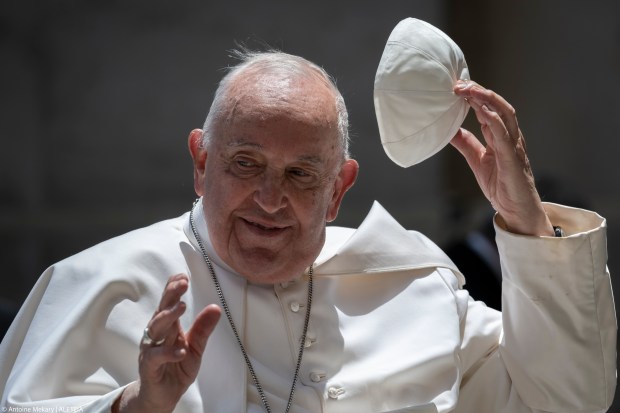 Pope Francis greets the crowd as he leaves after celebrating a mass on World Children's Day at St Peter's Basilica in the Vatican on May 26, 2024.