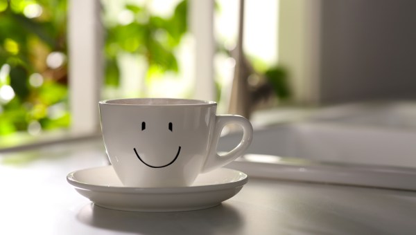 Delicious coffee in cup with happy face on kitchen countertop