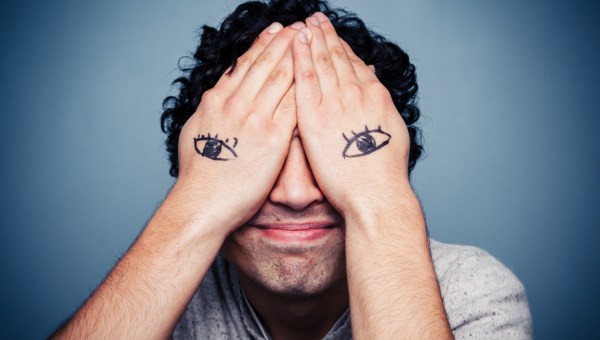 Man with eyes painted on his hands